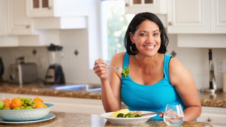 A woman eating a meal and celebrating her control over her hormonal changes.