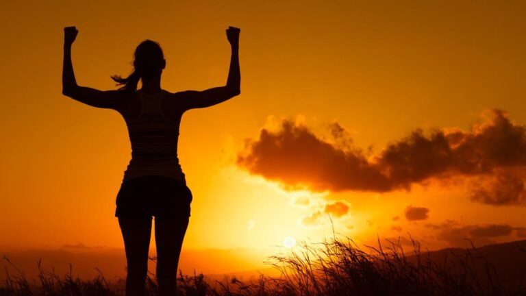 Strong female standing in a sunset background to help explain anabolism.