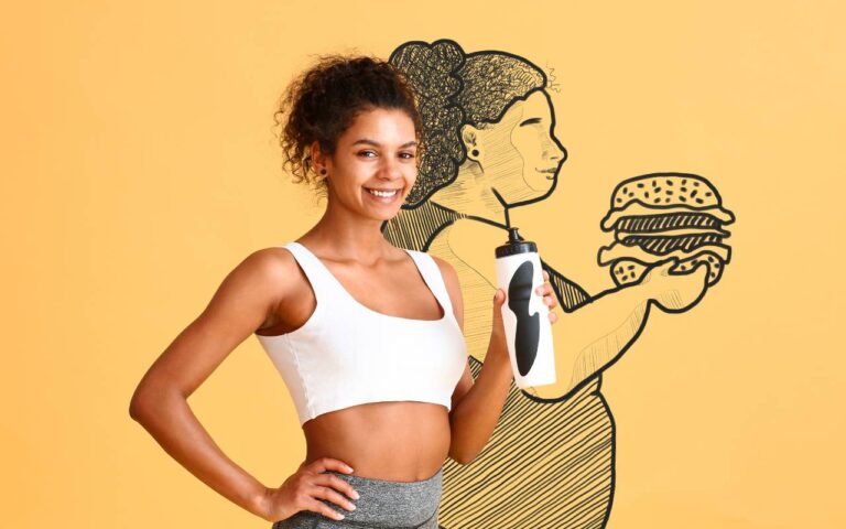 A fit woman standing in front of a drawing of her larger self while she drinks water to help with her weight loss.