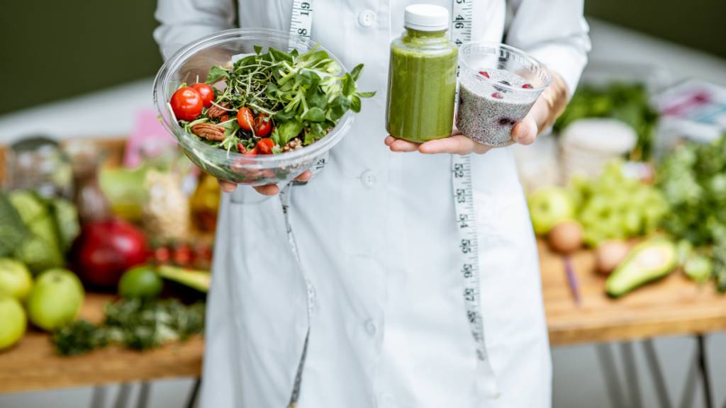A cropped view of a person holding healthy foods to highlight ways to achieve a metabolic reset.