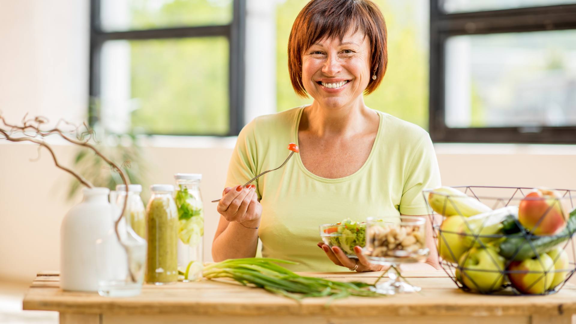 older woman sitting at table eating a healthy meal