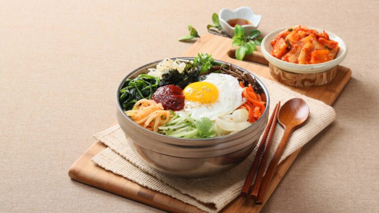 healthy bowl of food with eggs, vegetables, and condiments